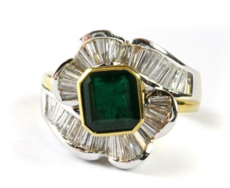 An 18ct yellow gold flower shaped ring set with an emerald cut emerald and baguette cut diamonds, with a ring certificate, st