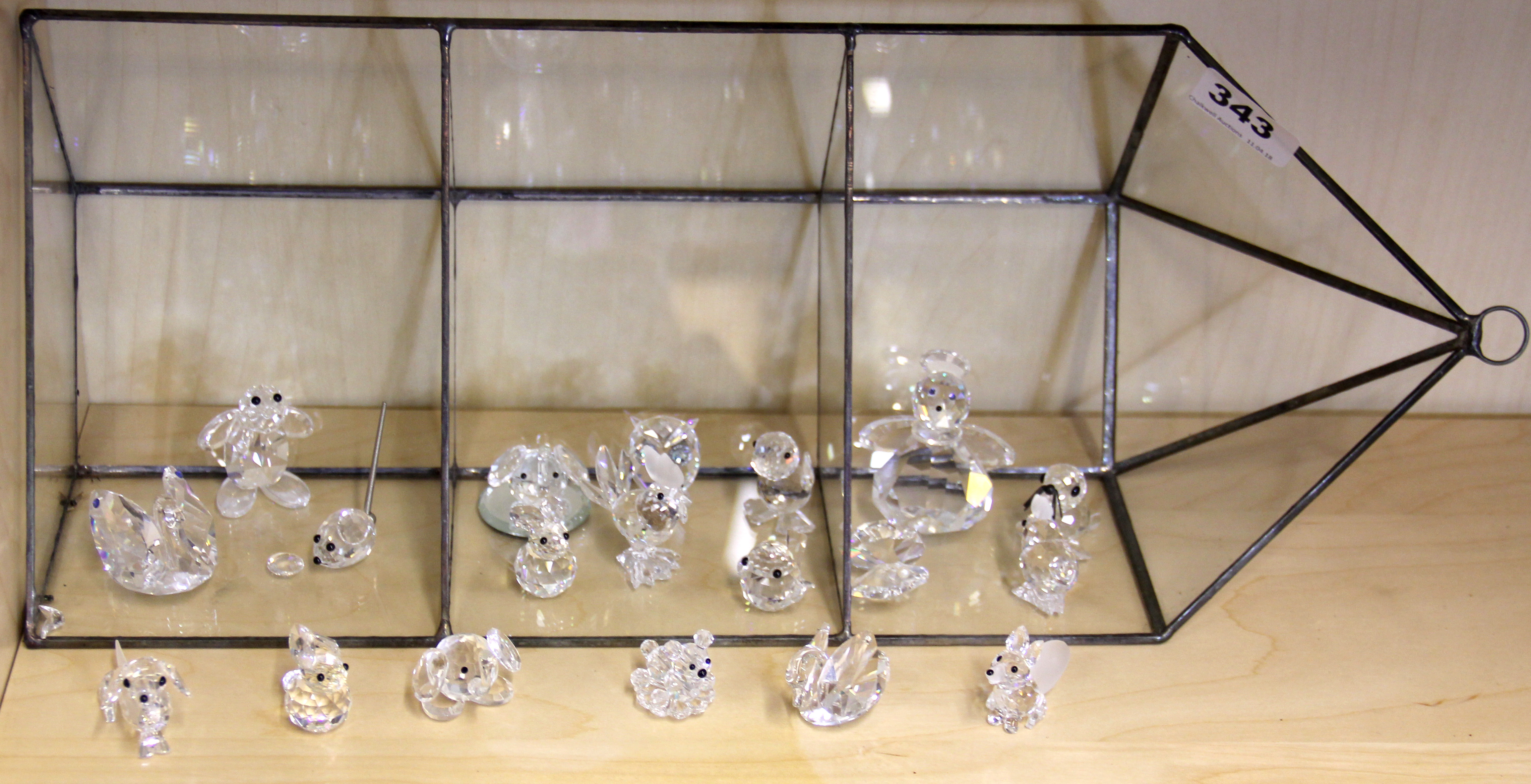 A quantity of Swarovski crystal figures with a wall mounted glass