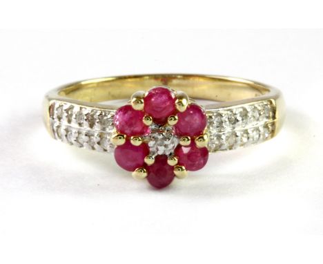 A 9ct yellow gold ruby and diamond set flower shaped cluster ring with diamond set shoulders, (M.5).