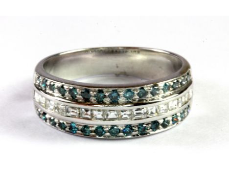 A white metal (tested 14ct gold) three row half eternity ring set with baguette cut diamonds and brilliant cut fancy blue dia