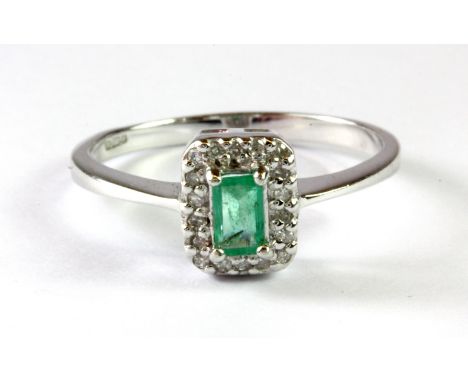 A 9ct white gold cluster ring set with an untreated Columbian emerald and diamonds, (N.5).
