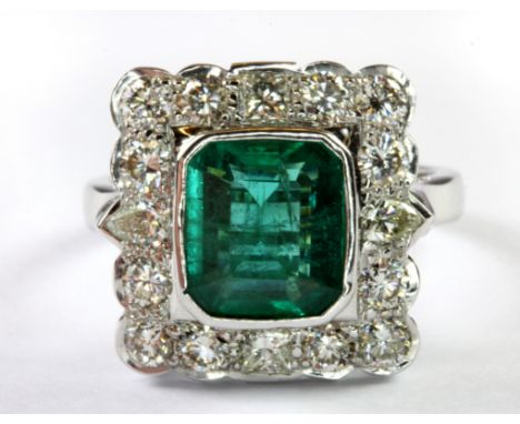 A 14ct white gold cluster ring set with an emerald surrounded by princess, brilliant and pear cut diamonds, (Q).