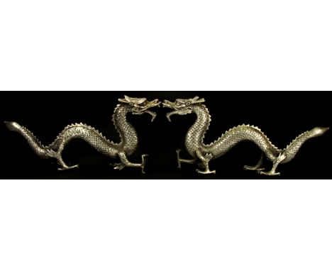 A pair of silvered bronze figures of dragons, L. 50cm.