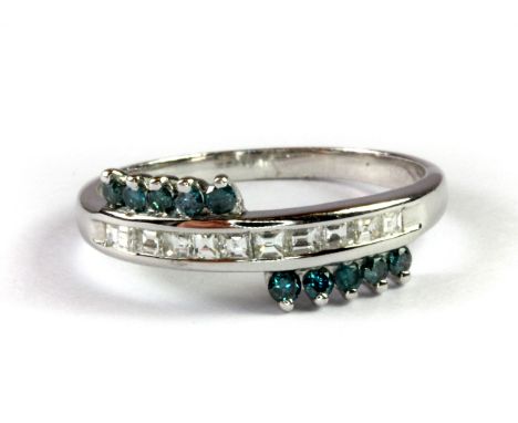 A 9ct white gold crossover ring set with baguette cut diamonds and brilliant cut fancy blue diamonds, (N).