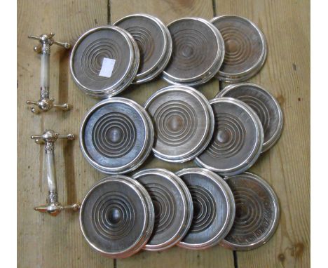 A box containing a set of twelve silver plated wine coasters with turned oak centres and a pair of knife rests with mother-of