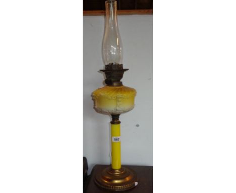 A Victorian oil lamp with brass foot, opaque yellow glass column and reservoir and double burner with clear glass chimney (a/