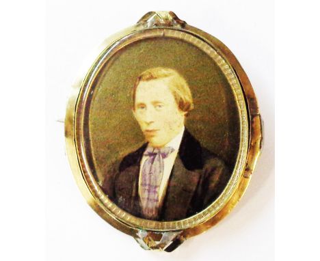 A 5.5cm Victorian ornate gilt metal oval swivel brooch with overpainted photographic portrait and decorative hair panel verso