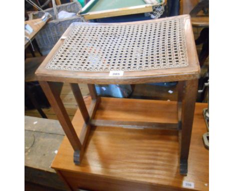 A 1930's stained oak dressing stool with rattan seat panel, set on moulded standard ends