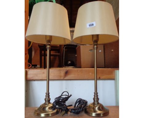 A pair of modern metal table lamps of slender candlestick form with brassed finish