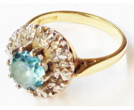 An aquamarine and diamond chip ring - bo A retro 18ct. gold ring, set with central aquamarine within a diamond chip border - 