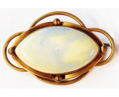 A gilt metal open framed brooch, set with a 4.5cm elliptical Ruskin opal effect pottery panel