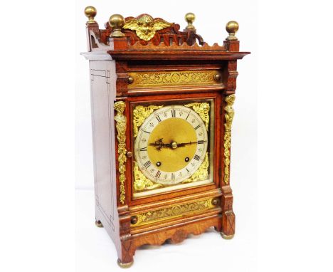 An early 20th Century brass mounted oak cased mantel clock with decorative spandrels and silvered chapter ring, with Winterha