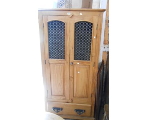 A 93cm modern pine wardrobe with hanging space enclosed by a pair of decorative cast and pierced metal panelled doors, over a