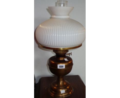 A brass oil lamp with duplex double burner, clear glass chimney and large opaque glass shade