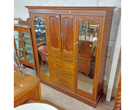 A 1.89m Edwardian mahogany and strung triple wardrobe with moulded cornice, central cupboard, two short and three long drawer