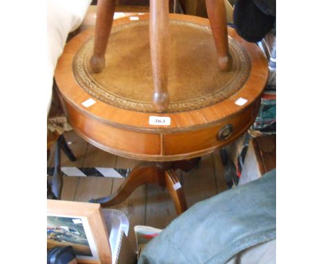 A 50cm diameter reproduction mahogany drum table with leather inset top and three drawers, set on turned pillar and tripod ba