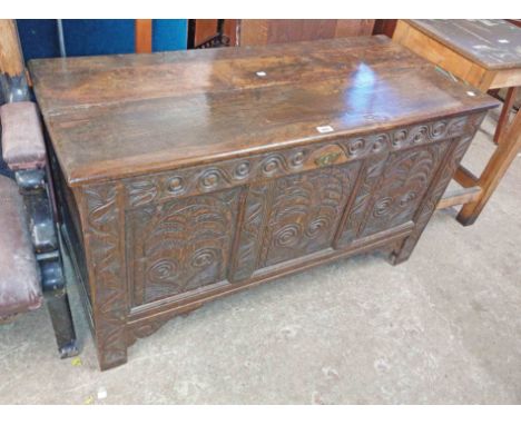 A 1.22m antique old oak coffer with carved decoration to triple panel front, set on block feet