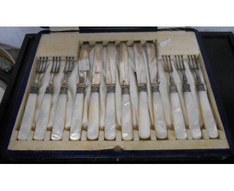 A cased set of six each silver plated fruit knives and forks with silver ferrules and mother-of-pearl handles