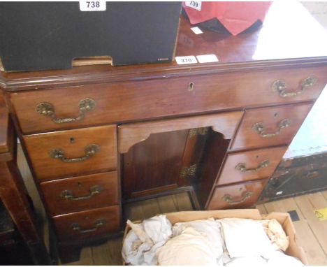 A 69cm antique mahogany kneehole desk with long frieze drawer, blind drawer under, six flanking short drawers and central cup