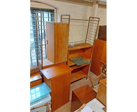 A retro Staples Ladderax teak effect storage system with three metal ladder supports, five bookcase sections enclosed by slid