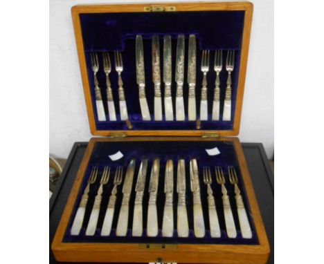 An oak cased set of twelve each silver plated fruit knives and forks with mother-of-pearl handles