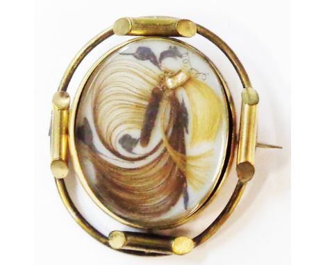 A 6cm Victorian ornate gilt metal oval swivel brooch with decorative hair and seed pearl panel, with later print verso