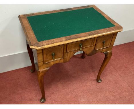 An AXIII Century and Later Walnut Lowboy, the crossbanded top with green baize insert over three drawers with feather banding