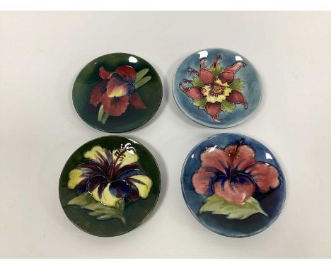 Four Various Moorcroft Pottery Circular Dishes, in the 'Hibiscus' and 'Orchid' patterns against green and blue grounds, impre