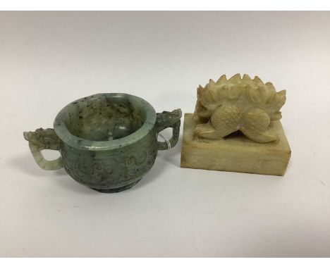 A Chinese Carved Jade Twin Handled Censer, with dragon formed handles and archaic style panels, the base applied with sticker