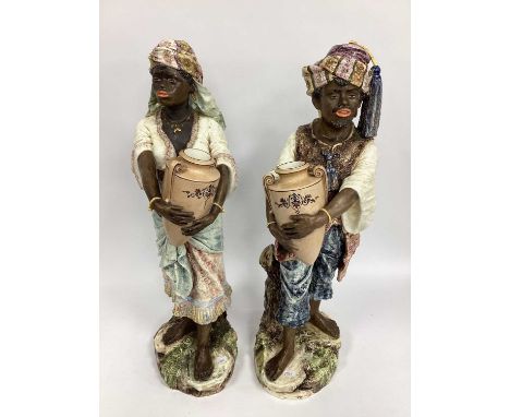 A Pair of Late XIX Century Continental Pottery Figures of an African Lady and Gentleman, each in traditional costume and head