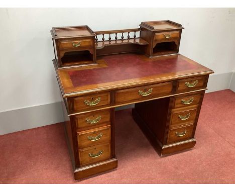 An Early XX Century Mahogany Pedestal Desk, the upper section with centre rail, turned spindles, shaped shelf and two small d