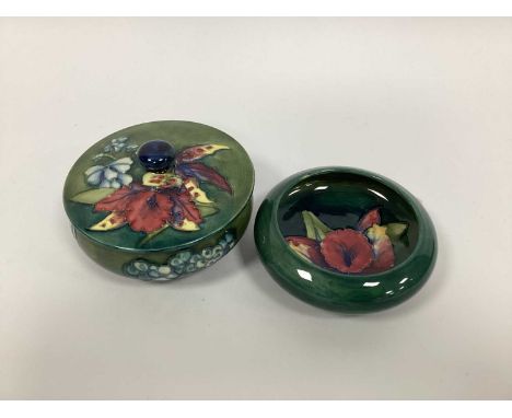 A Moorcroft Pottery Powder Bowl and Cover, of circular form painted in the 'Orchid' pattern against a shaded blue/green groun