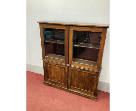 A XIX Century Rosewood Cabinet, with twin upper glazed doors with two internal shelves over panelled doors, on bracket feet, 