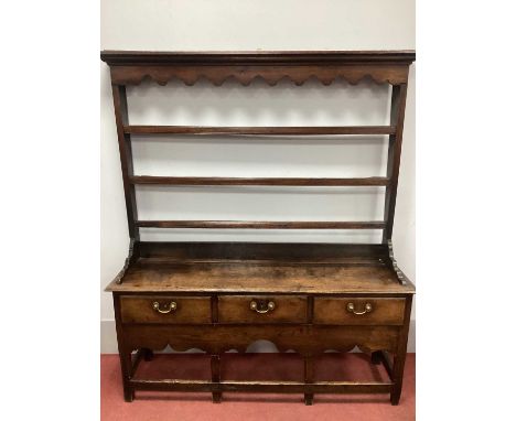 A Mid XVIII Century Joined Oak Dresser, the rack with a stepped moulded cornice, shaped pelmet and three open shelves, the ba