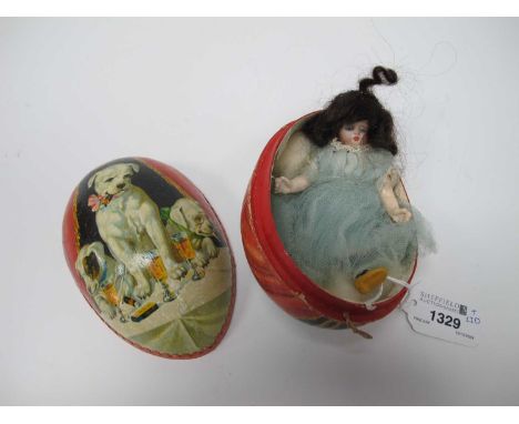 A Late XIX Century German Bisque Headed Doll, in period blue and lace dress, 12cm long contained in a vintage Easter egg box 