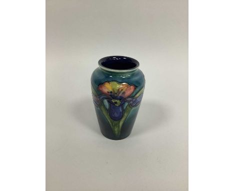 A Moorcroft Pottery Vase, of baluster form painted in the 'Orchid' pattern against a blue ground, impressed marks, 13cm high.