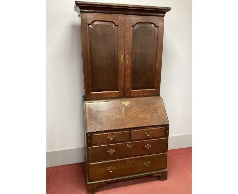 A Georgian Oak Bureau Bookcase, with twin panelled doors over fall front, fitted interior over two small and two long drawers