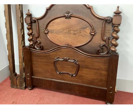 A XIX Century Mahogany Bed, the headboard with an arched top and applied oval panel, barleytwist and block supports, the foot