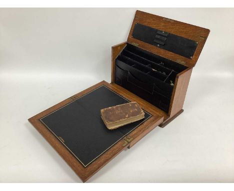 An Early XX Century Oak Travelling Writing Box, with brass carrying handle, the fall front opening to reveal a writing slope,