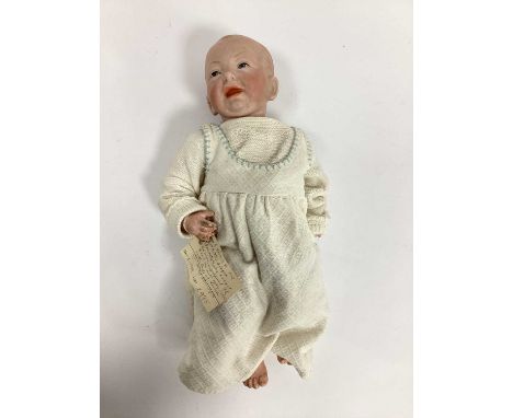 A Kammer &amp; Reinhardt Bisque Headed Baby Doll, with painted features and composition body, 36cm long.