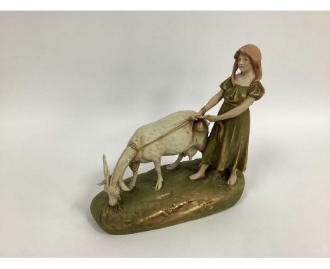 A Royal Dux Porcelain Model of a Girl Holding a Goat, on a rocky mound, oval base, pink triangle mark, shape number 1493, 29c