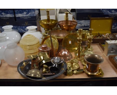 An assorted group of copper and brass metalware, to include a planished copper bowl, trivets, various candlesticks, a Henry L