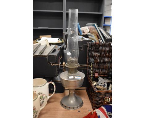A 1930s Aladdin oil lamp, with glass chimney, measuring 60cm tall