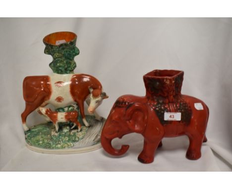 A Chinese red ground elephant vase together with a 19th Century Staffordshire porcelain vase, modelled as a cow and calf, mea