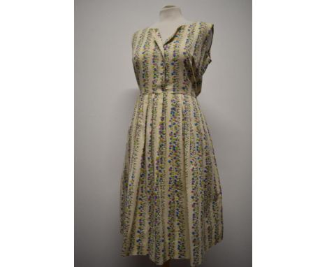 A 1950s medium weight floral cotton day dress having pleated skirt, button front and side press stud fastening, medium size.