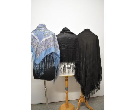 Three shawls, to include early 20th century paisley silk shawl and two late 19th/ early 20th century black fringed shawls, on