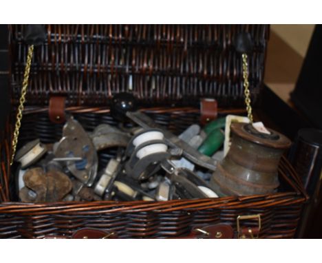 A wicker basket containing vintage nautical accessories, including a Tuph-Fittings winch, and other items