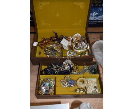 A vintage studded leatherette jewellery box containing an assorted collection of costume jewellery, including strings of synt