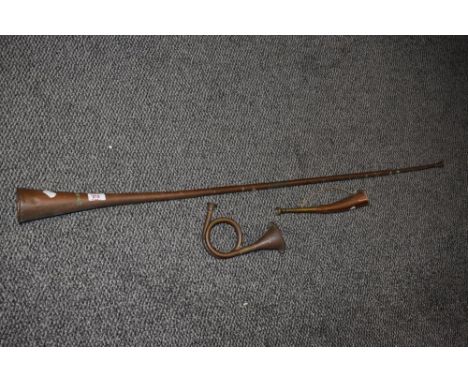 Three 19th Century copper and brass hunting horns, the largest measuring 120cm long