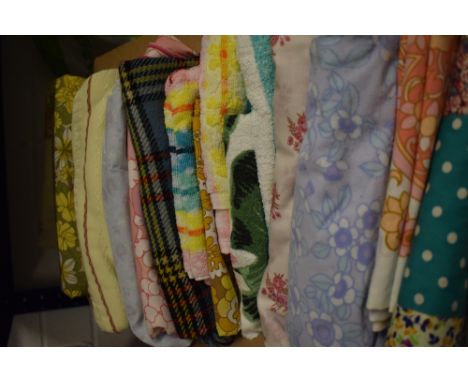 A box full of vintage and retro bedding, towels, a table cloth, a travel rug and similar.